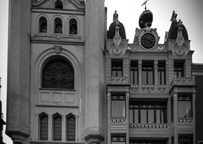 Fotografía en blanco y negro de la fachada de la ermita de la Virgen de a Soledad en Badajoz y el edificio de las 3 campanas